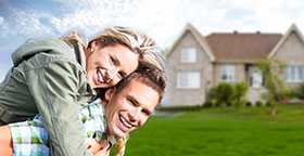 Smiling Couple in front of a Home